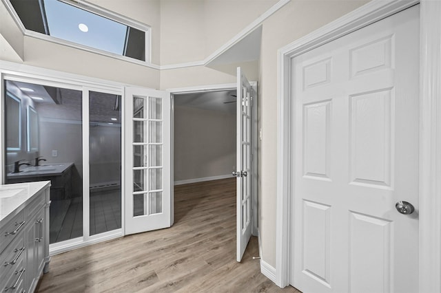 bathroom featuring hardwood / wood-style flooring, vanity, a towering ceiling, and french doors