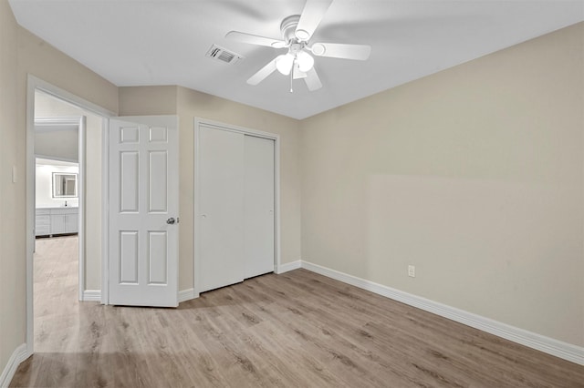 unfurnished bedroom featuring ceiling fan, light hardwood / wood-style floors, and a closet