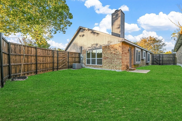 back of property featuring central air condition unit and a lawn