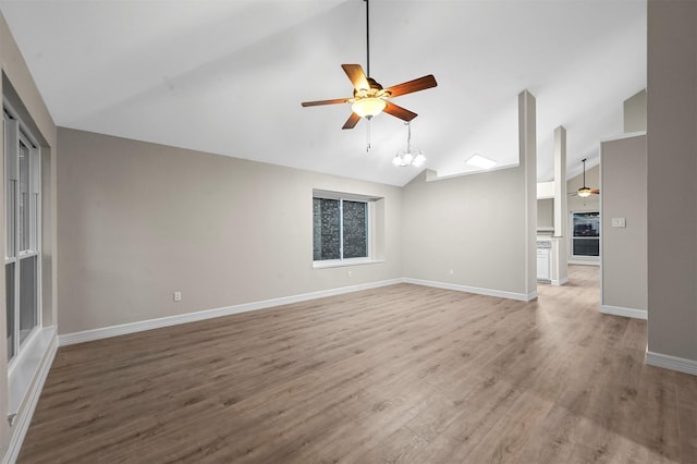 unfurnished living room with hardwood / wood-style flooring, a notable chandelier, and lofted ceiling