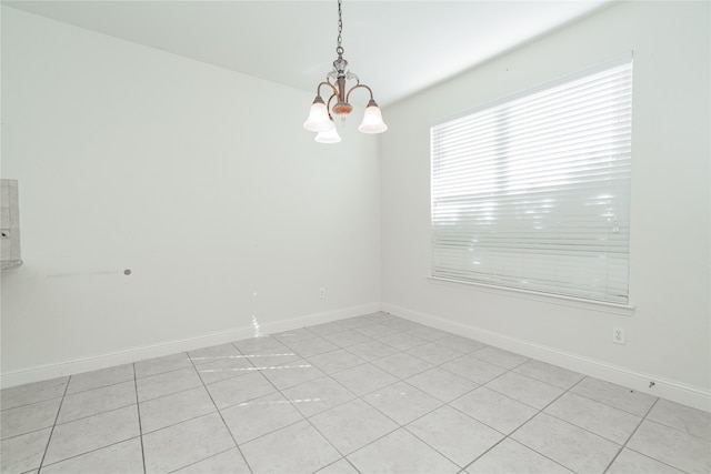 tiled empty room with a chandelier