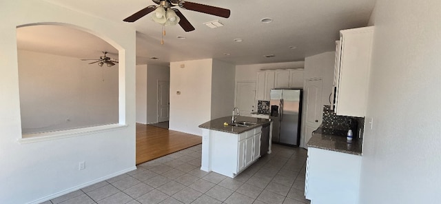 kitchen featuring sink, light tile patterned floors, white cabinetry, a kitchen island with sink, and stainless steel appliances