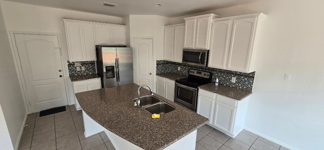 kitchen featuring stainless steel appliances, an island with sink, sink, and white cabinets