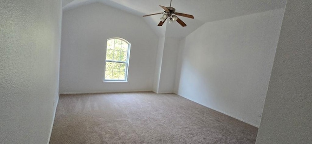 carpeted spare room with vaulted ceiling and ceiling fan