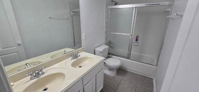 full bathroom featuring tile patterned flooring, vanity, toilet, and combined bath / shower with glass door