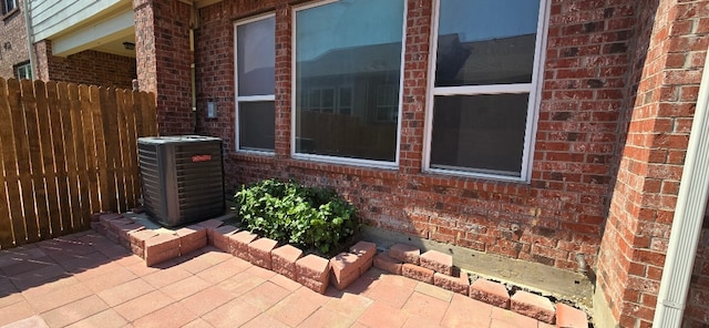 view of side of home with cooling unit and a patio