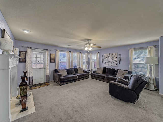 living room featuring light carpet, a textured ceiling, ceiling fan, and a healthy amount of sunlight