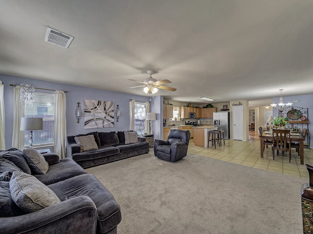 living room featuring ceiling fan with notable chandelier, light tile patterned floors, a textured ceiling, and a wealth of natural light