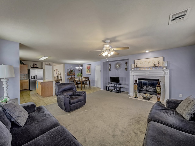 living room with ceiling fan, a fireplace, and light colored carpet