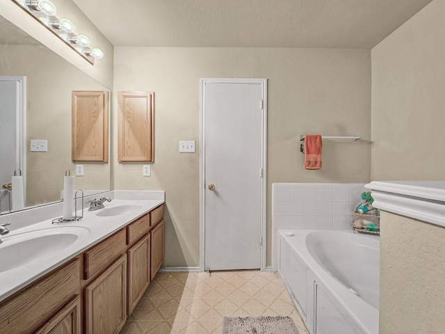 bathroom featuring vanity, a textured ceiling, and a washtub