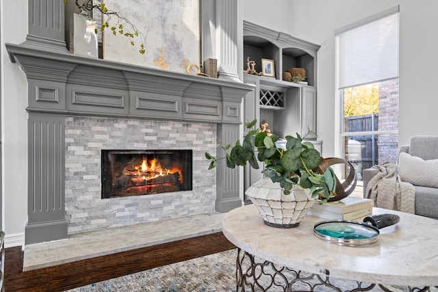 interior space featuring hardwood / wood-style floors, built in features, and a tiled fireplace