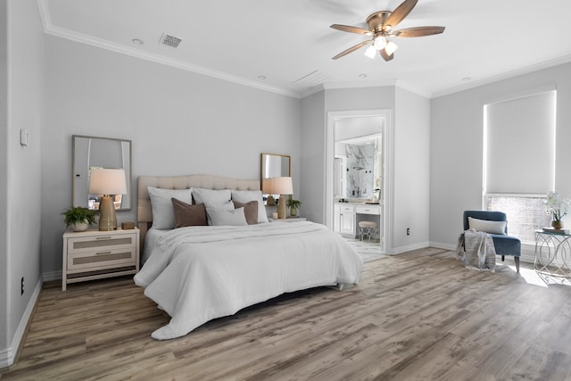 bedroom featuring connected bathroom, hardwood / wood-style flooring, ceiling fan, and crown molding