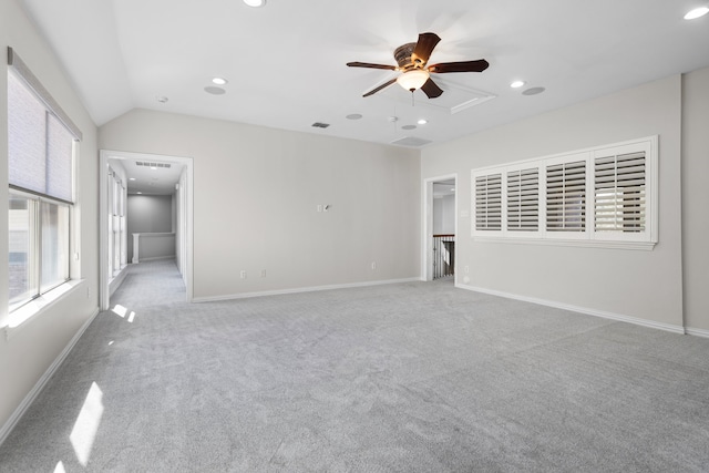 carpeted empty room featuring vaulted ceiling, plenty of natural light, and ceiling fan