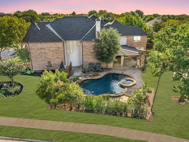 pool at dusk with a lawn and a patio