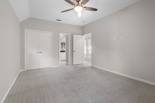 unfurnished bedroom with ceiling fan, lofted ceiling, and a closet