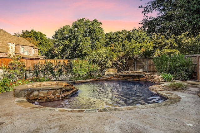 pool at dusk featuring pool water feature