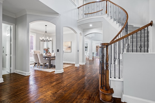 foyer entrance featuring a notable chandelier, dark hardwood / wood-style floors, and ornamental molding