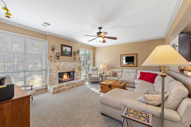 living room with carpet flooring, ceiling fan, ornamental molding, and a fireplace