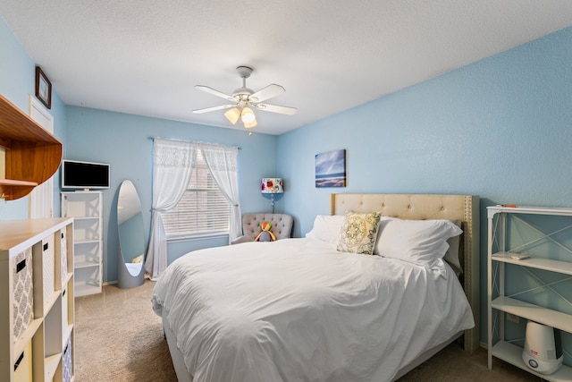 carpeted bedroom featuring ceiling fan and a textured ceiling