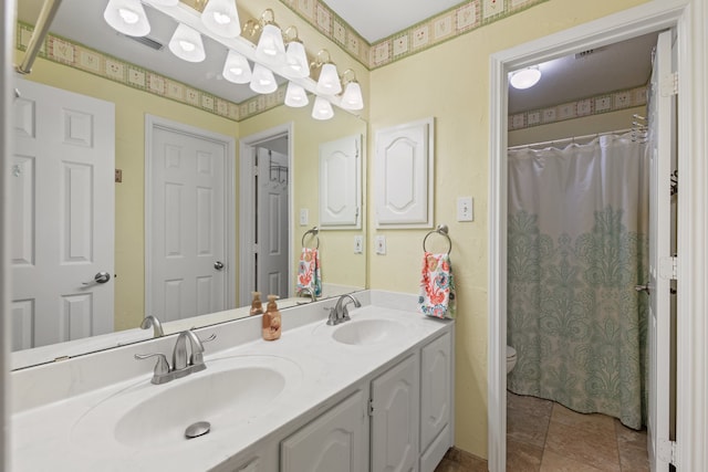 bathroom featuring tile patterned flooring, vanity, and toilet