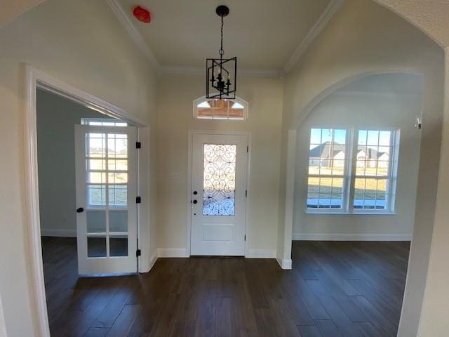 doorway to outside featuring crown molding, dark wood-type flooring, and a chandelier