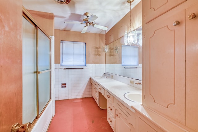 bathroom featuring ceiling fan, combined bath / shower with glass door, tile walls, and a wealth of natural light