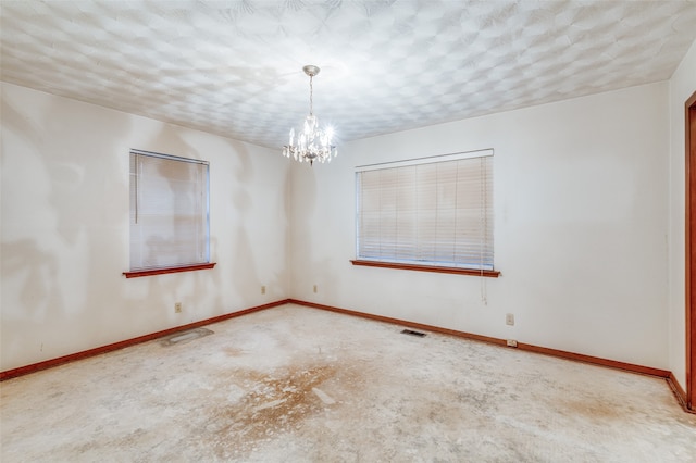 unfurnished room with a textured ceiling and an inviting chandelier