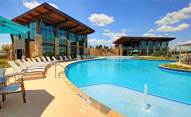 view of pool with pool water feature and a patio