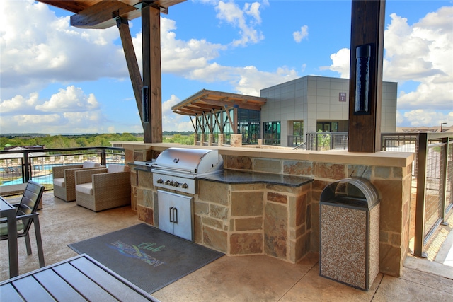 view of patio featuring a grill, an outdoor living space, a bar, and exterior kitchen