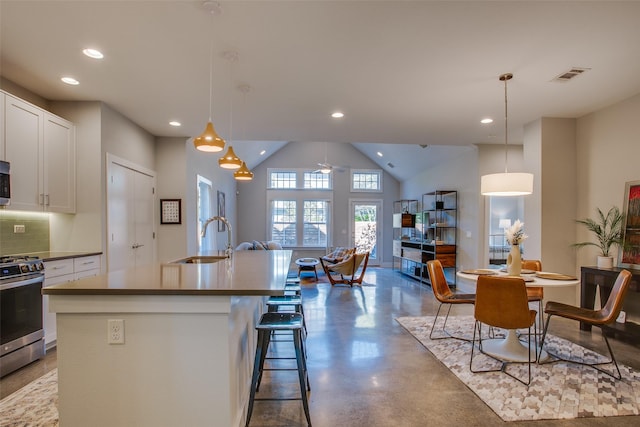 kitchen featuring pendant lighting, stainless steel appliances, and an island with sink