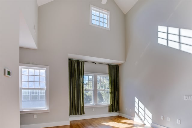 interior space featuring a healthy amount of sunlight, light wood-type flooring, and high vaulted ceiling