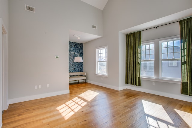 interior space featuring light wood-type flooring and high vaulted ceiling