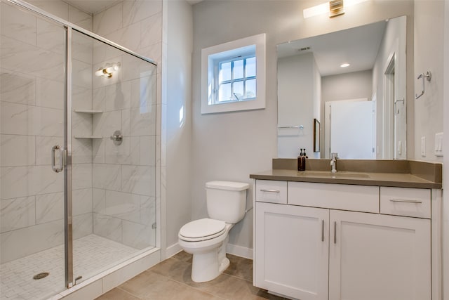 bathroom with tile patterned flooring, vanity, toilet, and walk in shower