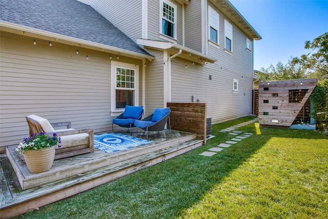 back of property with a yard, an outdoor living space, a shed, and a deck