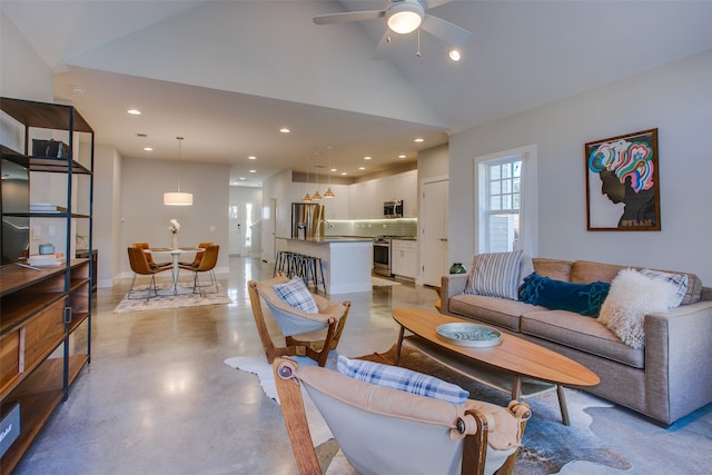 living room featuring ceiling fan, lofted ceiling, and sink