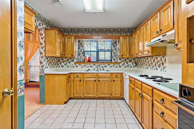 kitchen with stainless steel oven, a textured ceiling, white dishwasher, sink, and light tile patterned flooring