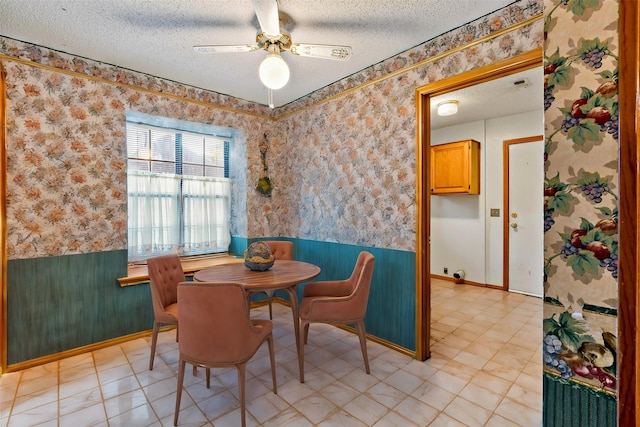 dining area with a textured ceiling and ceiling fan