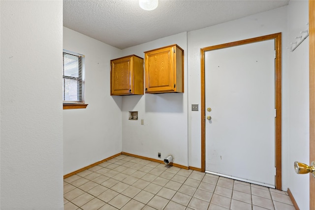 washroom featuring light tile patterned floors, cabinets, a textured ceiling, and washer hookup