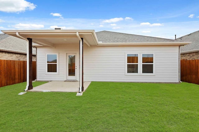 back of house with a yard and a patio