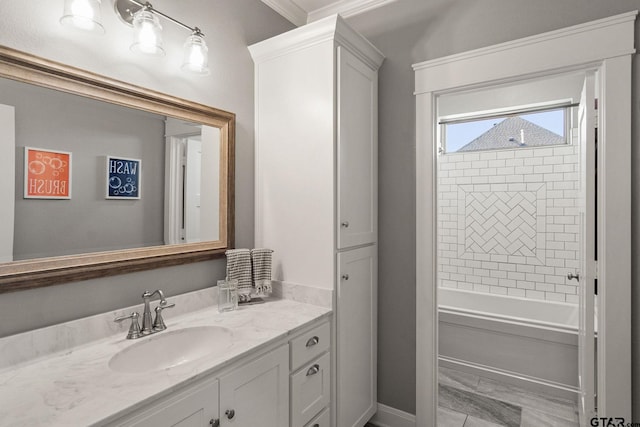 bathroom with vanity, crown molding, and tiled shower / bath