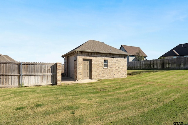 rear view of property featuring a lawn and an outdoor structure