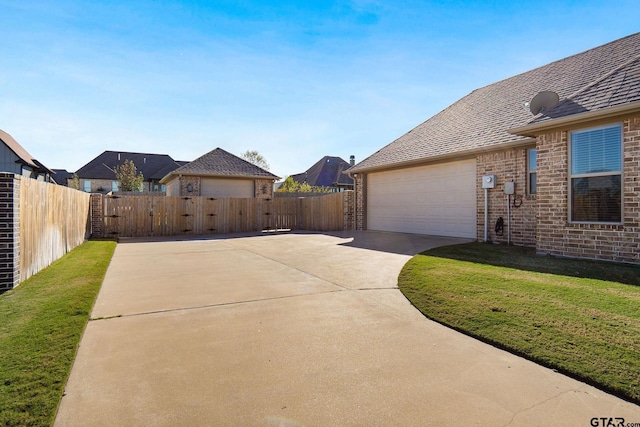 view of side of property with a garage and a lawn