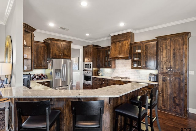 kitchen with kitchen peninsula, crown molding, stainless steel appliances, and dark hardwood / wood-style floors