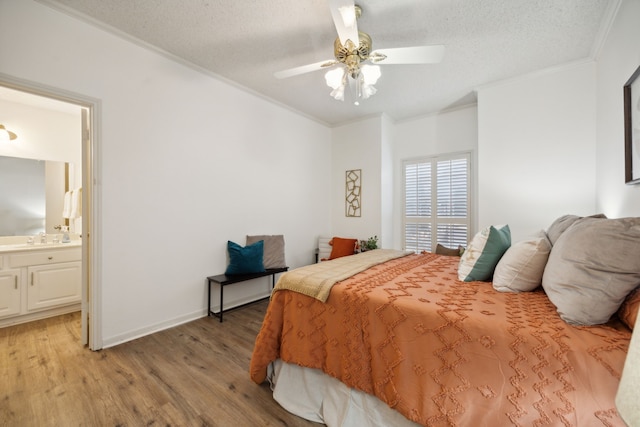 bedroom with ceiling fan, ensuite bathroom, light hardwood / wood-style floors, a textured ceiling, and ornamental molding