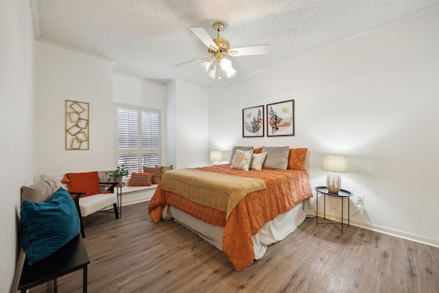 bedroom with ceiling fan, wood-type flooring, a textured ceiling, and ornamental molding