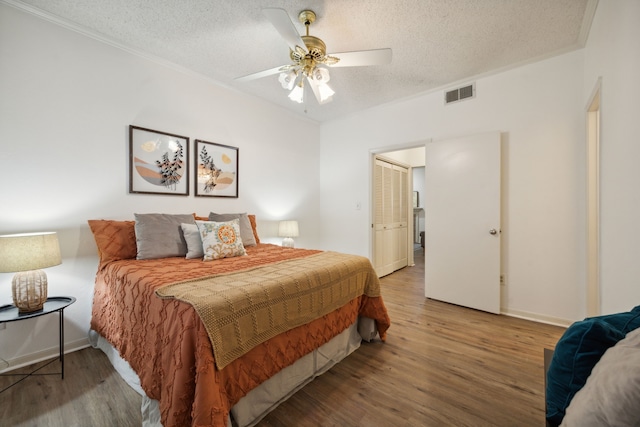 bedroom featuring ceiling fan, wood-type flooring, and a textured ceiling