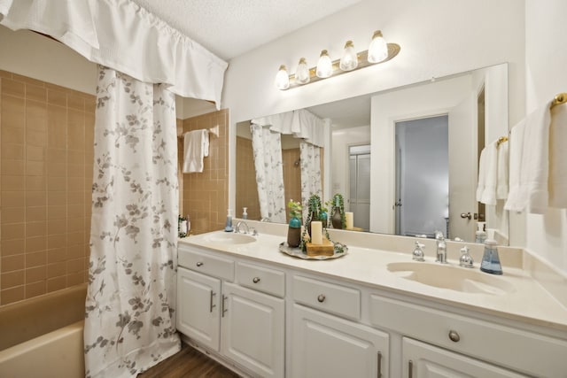 bathroom featuring vanity, hardwood / wood-style floors, a textured ceiling, and shower / bath combo