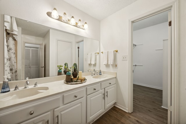 bathroom featuring vanity, a textured ceiling, and hardwood / wood-style flooring