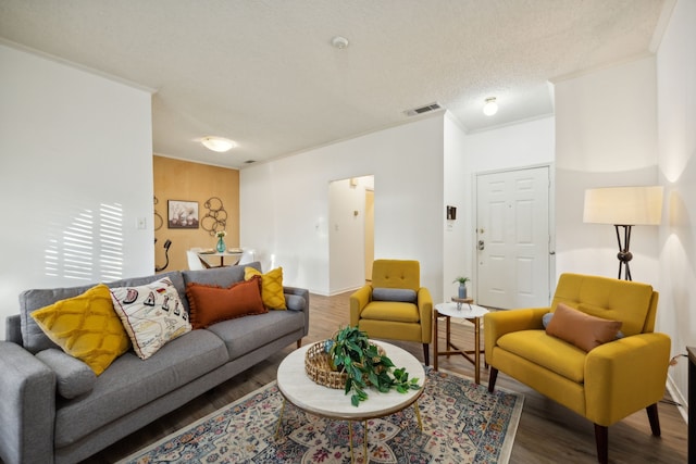 living room featuring hardwood / wood-style floors, a textured ceiling, and ornamental molding