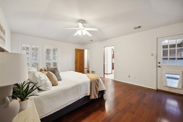 bedroom featuring dark hardwood / wood-style flooring, heating unit, and ceiling fan